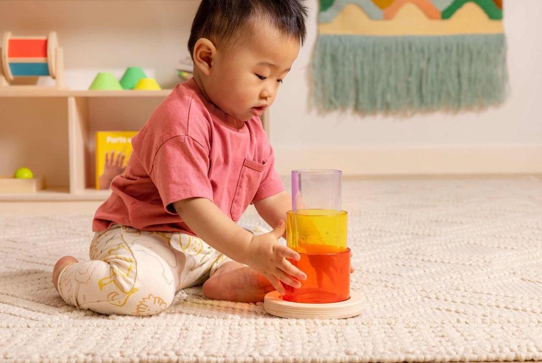 幼儿专注地玩分龄玩具 / A toddler absorbed in stage-based play
